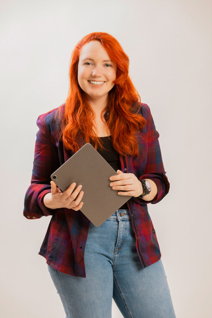 Lisa freut sich auf das Tauschgeschäft und hält einen Laptop in der Hand.
