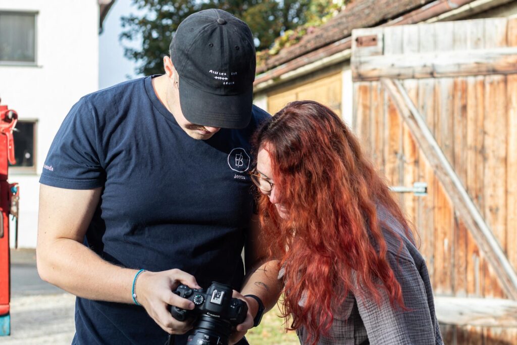 Jonas und Lisa schauen gemeinsam die Ergebnisse des Fotoshootings auf der Kamera an.